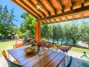 a wooden table and chairs under a wooden pergola at Holiday Home Podere Cerbaia - SMR100 by Interhome in Santa Maria a Monte