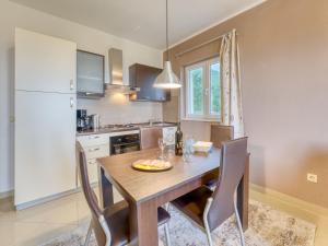 cocina con mesa de comedor de madera y sillas en Apartment Villa Tara-2 by Interhome, en Brseč