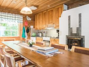 une cuisine avec une table en bois et une cheminée dans l'établissement Holiday Home Karjalan kelohuvila by Interhome, à Muurasjärvi