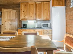 une cuisine avec une table en bois et un réfrigérateur dans l'établissement Holiday Home Karjalan kelohuvila by Interhome, à Muurasjärvi