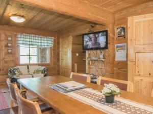 une salle à manger avec une table en bois et une télévision dans l'établissement Holiday Home Karjalan kelohuvila by Interhome, à Muurasjärvi