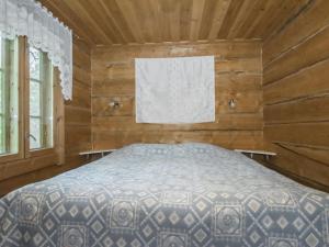 une chambre avec un lit dans une cabane en bois dans l'établissement Holiday Home Karjalan kelohuvila by Interhome, à Muurasjärvi 15 autres photos