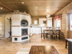 een woonkamer met een open haard en een tafel en stoelen bij Holiday Home Liisakallela by Interhome in Sonkajärvi