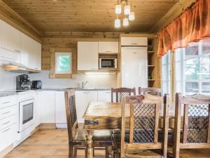 een keuken met een houten tafel en stoelen in een kamer bij Holiday Home Liisakallela by Interhome in Sonkajärvi