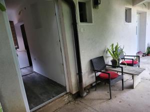 Zimmer mit 2 Stühlen, einem Tisch, einem Tisch und einer Bank in der Unterkunft Apartman u centru Prnjavor in Prnjavor