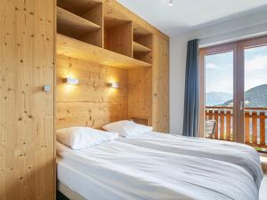 a bedroom with a bed and a large window at Apartment T-Resort La Tzoumaz 3p6 vue vallée by Interhome in La Tzoumaz
