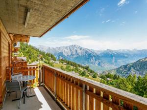 einen Balkon mit einem Tisch, Stühlen und Bergen in der Unterkunft Apartment T-Resort La Tzoumaz 3p6 vue vallée by Interhome in La Tzoumaz