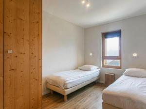 een slaapkamer met 2 bedden en een raam bij Apartment T-Resort La Tzoumaz 3p6 vue vallée by Interhome in La Tzoumaz