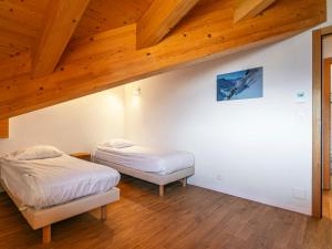 2 letti in una camera con soffitto in legno di Apartment T-Resort La Tzoumaz 4p8 by Interhome a La Tzoumaz