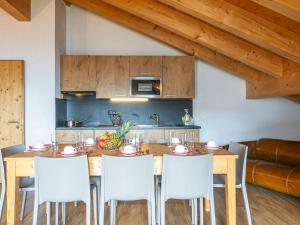 ラ・ズマにあるApartment T-Resort La Tzoumaz 4p8 by Interhomeのキッチン(木製テーブル、白い椅子付)