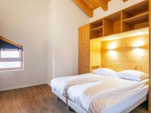 una camera con un grande letto con testiera in legno di Apartment T-Resort La Tzoumaz 4p8 vue vallée by Interhome a La Tzoumaz