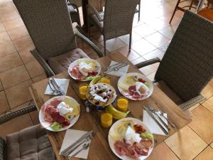 a wooden table with plates of food on it at Penzion Sklář in Nový Bor