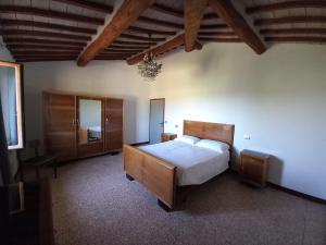 una camera con un grande letto e uno specchio di Colle Costanza a Todi