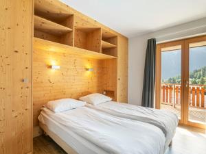 ラ・ズマにあるApartment T-Resort La Tzoumaz 4p10 by Interhomeの木製の壁のベッドルーム1室(大型ベッド1台付)