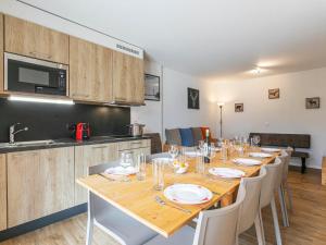 a dining room with a table and a kitchen at Apartment T-Resort La Tzoumaz 4p10 by Interhome in La Tzoumaz