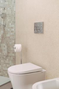 a bathroom with a white toilet and a shower at Orange Boutique Residence - Casa Diogo in Quarteira