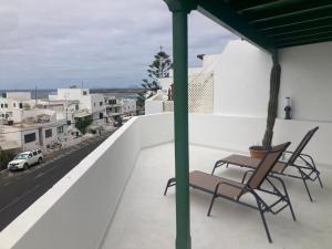 two chairs on a balcony with a view of a city at El Marinero, piso 2 y piso 3 in La Santa