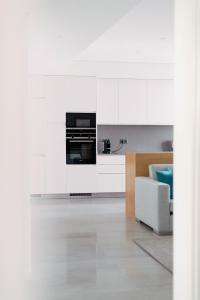 a living room with white cabinets and a white couch at Orange Boutique Residence - Casa Diogo in Quarteira