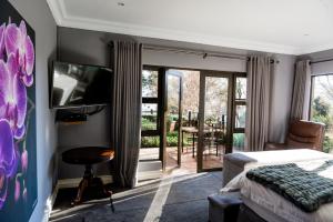 a bedroom with a bed and a tv and a balcony at Valhalla, Cathkin Park in Bergview