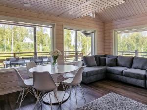 a living room with a couch and a table and chairs at Holiday Home Himoksen keiju 2 by Interhome in Jämsä +10 photos