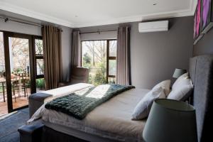 a bedroom with a bed and a large window at Valhalla, Cathkin Park in Bergview