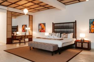 a bedroom with a large bed and a desk at Mosvold Villa in Ahangama