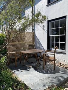 ein Picknicktisch und zwei Stühle neben einem Gebäude in der Unterkunft Lovely Cottage beside Surf Beaches & Bude Canal in Bude