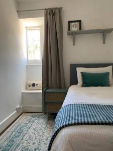 ein Schlafzimmer mit einem Bett und einem Fenster in der Unterkunft Lovely Cottage beside Surf Beaches & Bude Canal in Bude