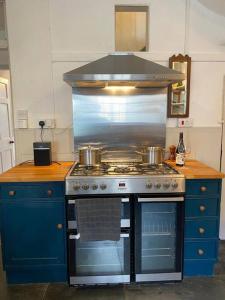 a kitchen with a stove with pots and pans on it at Lovely Cottage beside Surf Beaches & Bude Canal in Bude