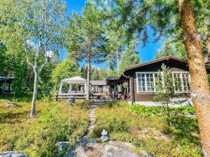 a house in the woods with a tree at Holiday Home Lauluranta by Interhome in Padasjoki