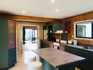eine Küche mit grünen Schränken und einer Arbeitsplatte in der Unterkunft Enjoyable Cozy Life Style Villa in Dairy Flat