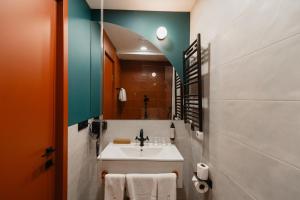 La salle de bains est pourvue d'un lavabo et d'un miroir. dans l'établissement About Sololaki, à Tbilissi