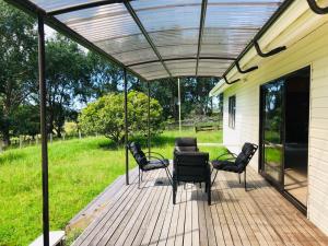 eine Terrasse mit Stühlen und Markise auf einem Haus in der Unterkunft Enjoyable Cozy Life Style Villa in Dairy Flat