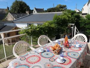 una mesa con un plato de comida en el balcón en Holiday Home La Glycine by Interhome, en Lampaul-Plouarzel