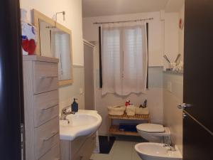 łazienka z 2 umywalkami, toaletą i oknem w obiekcie Pretty Home w mieście Acireale +26 zdjęć