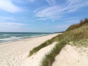 a sandy beach with the ocean in the background at Holiday Home Hillmari - 650m from the sea in Bornholm by Interhome in Vester Sømarken