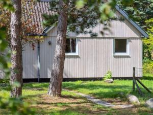 a house with trees in front of it at Holiday Home Hillmari - 650m from the sea in Bornholm by Interhome in Vester Sømarken