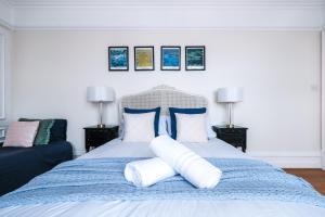 a bedroom with a blue bed with pillows at Harrods Knightsbridge Flat in Central KB89 in London