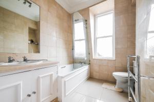 La salle de bains est pourvue d'un lavabo, de toilettes et d'un miroir. dans l'établissement Harrods Knightsbridge Flat in Central KB89, à Londres