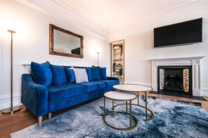 ロンドンにあるHarrods Knightsbridge Flat in Central KB89のリビングルーム(青いソファ、暖炉付)