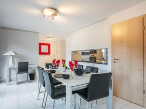 uma cozinha e sala de jantar com uma mesa branca e cadeiras em Apartment Vasco de Gama B6-R by Interhome em Bouveret