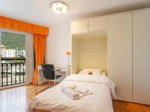 1 dormitorio con cama, escritorio y ventana en Apartment Vasco de Gama B6-R by Interhome, en Bouveret