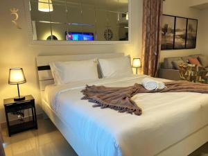 Un dormitorio con una gran cama blanca con una manta. en Studio Escape in Al Reem Oasis Euphoria en Abu Dabi