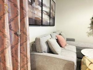 un soggiorno con divano grigio e 2 cuscini di Studio Escape in Al Reem Oasis Euphoria a Abu Dhabi