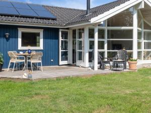 een huis met een terras met een tafel en stoelen bij Holiday Home Asvalde - all inclusive - 200m to the inlet by Interhome in Vordingborg