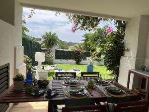uma mesa de jantar com vista para um jardim em La Alcaidesa Valerie Bruno em San Roque