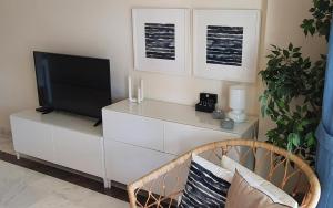 a living room with a television on a white dresser at La Alcaidesa Valerie Bruno in San Roque