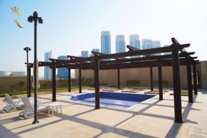 een pergola en een zwembad op een gebouw bij Studio Escape in Al Reem Oasis Euphoria in Abu Dhabi