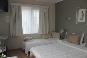 une chambre d'hôtel avec deux lits et un canapé dans l'établissement B&B Vanloo, à Westende