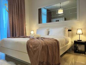 1 dormitorio con 1 cama blanca grande y espejo en Studio Escape in Al Reem Oasis Euphoria, en Abu Dabi